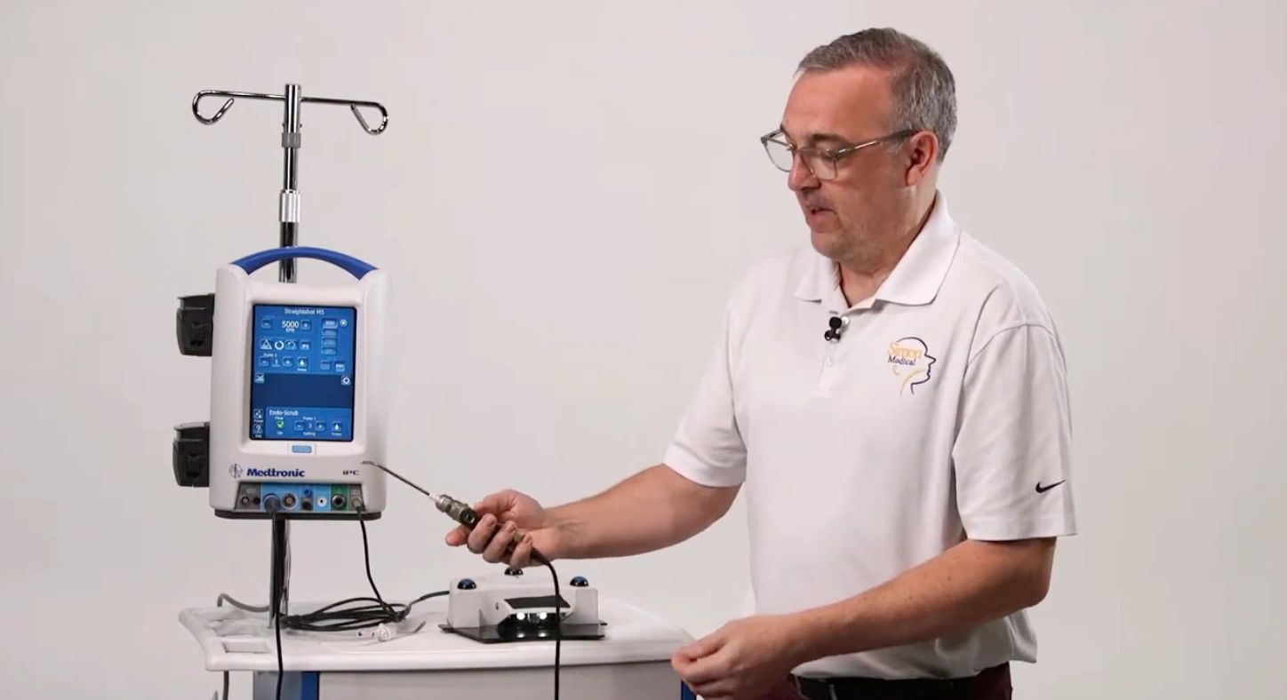 Simon Medical staff demonstrating a Medtronic Straightshot M5 console and handpiece